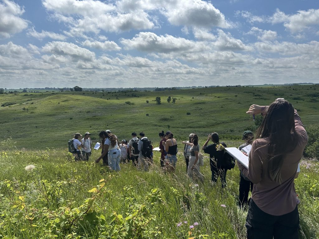 A large group of students write in notebooks in the Arb.