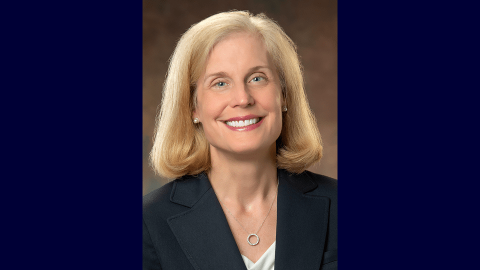 Headshot of Dr. Jennifer Pietenpol ’86 on a dark blue background.