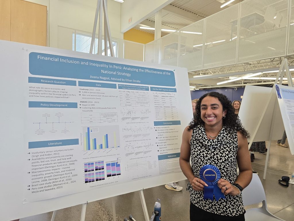 Photograph of Nagpal presenting her comps poster labeled "Financial Inclusion and Inequality in Perú: Analyzing the Effectiveness of the National Strategy