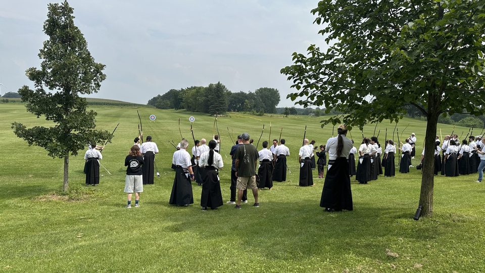Kyudo practitioners shooting long-range outside on campus