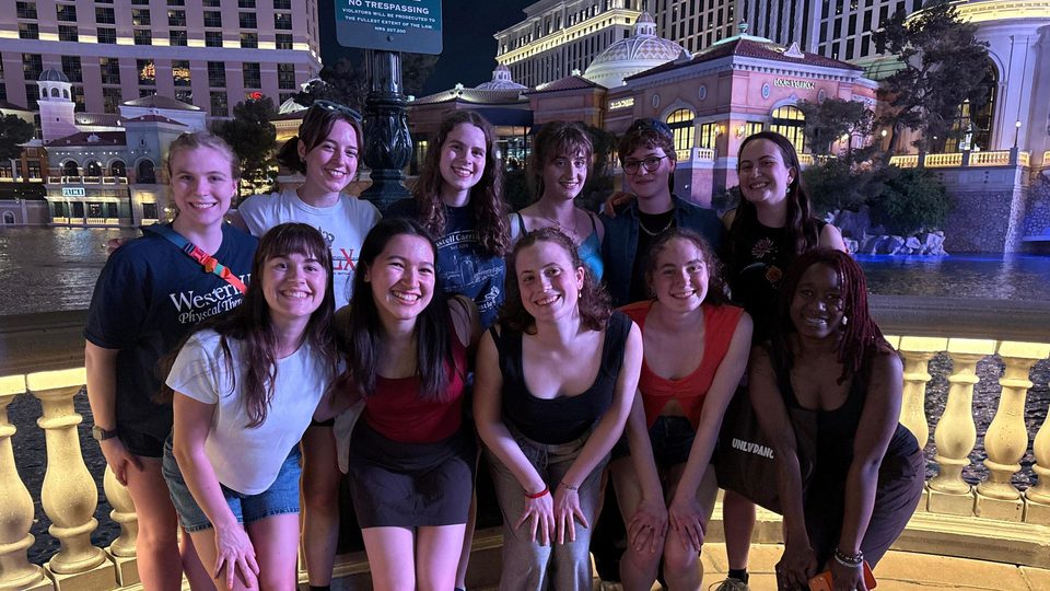 Group of Carleton students pose and smile at night in front of a Las Vegas fountain.