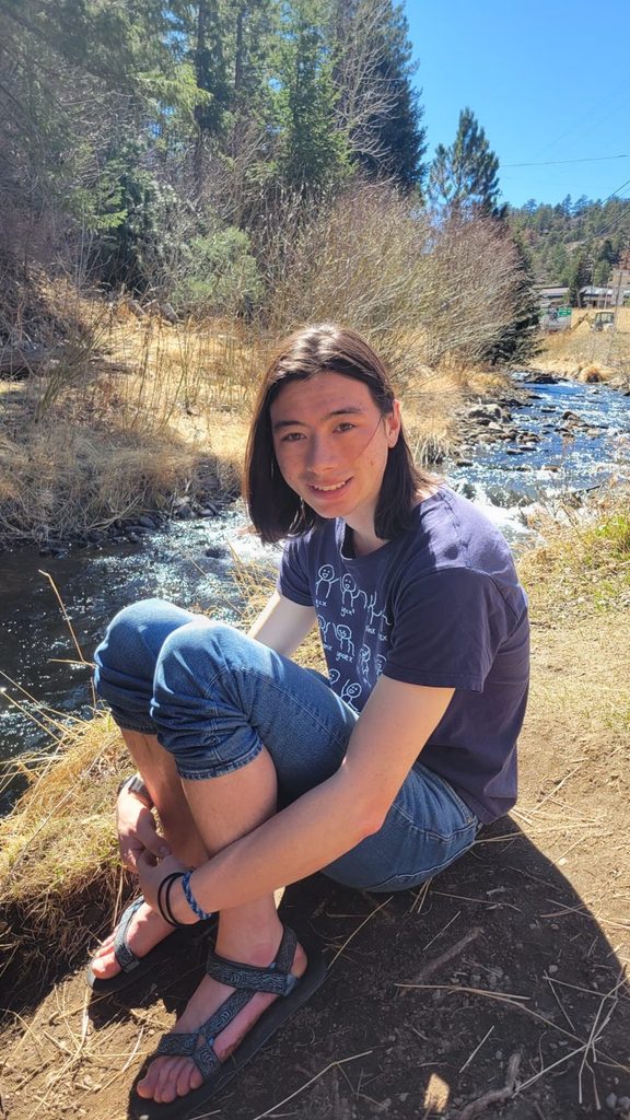 Sam Reiter ’27 sitting by a creek in the sun.