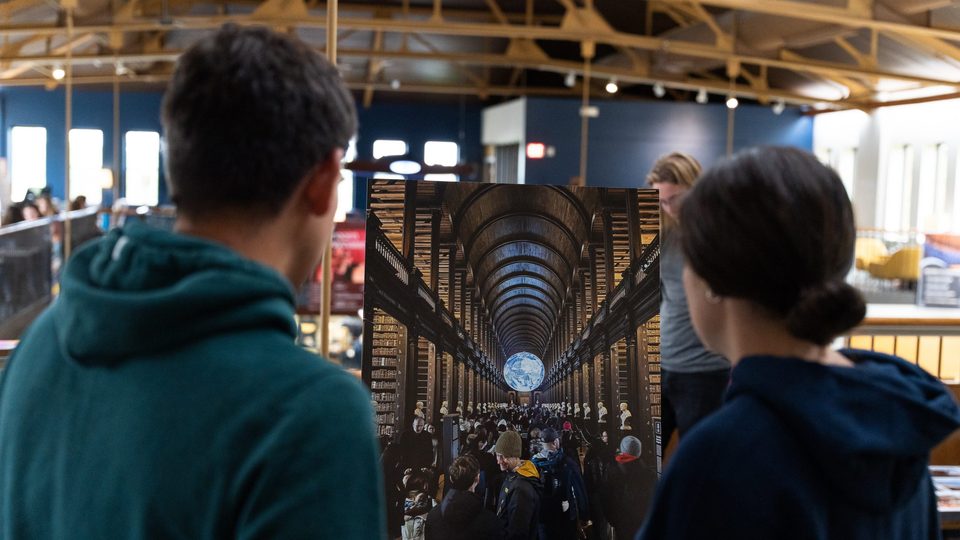 Two people look at a large print of a winning OCS photo in Upper Sayles.