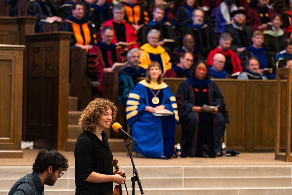 A student performer speaks at the front of the Chapel at Honors Convo.