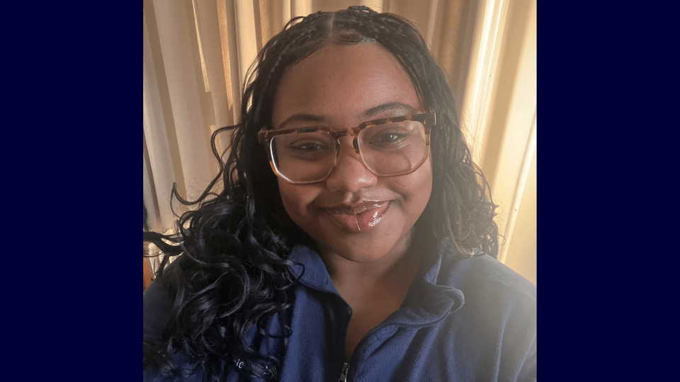 Selfie of Anniya Harris on a dark blue background.