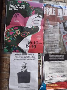 Murals and posters on a brick wall in Berlin