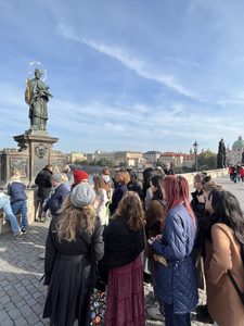 Students view the statue of St. John of Nepomuk on the Charles Bridge in Prague