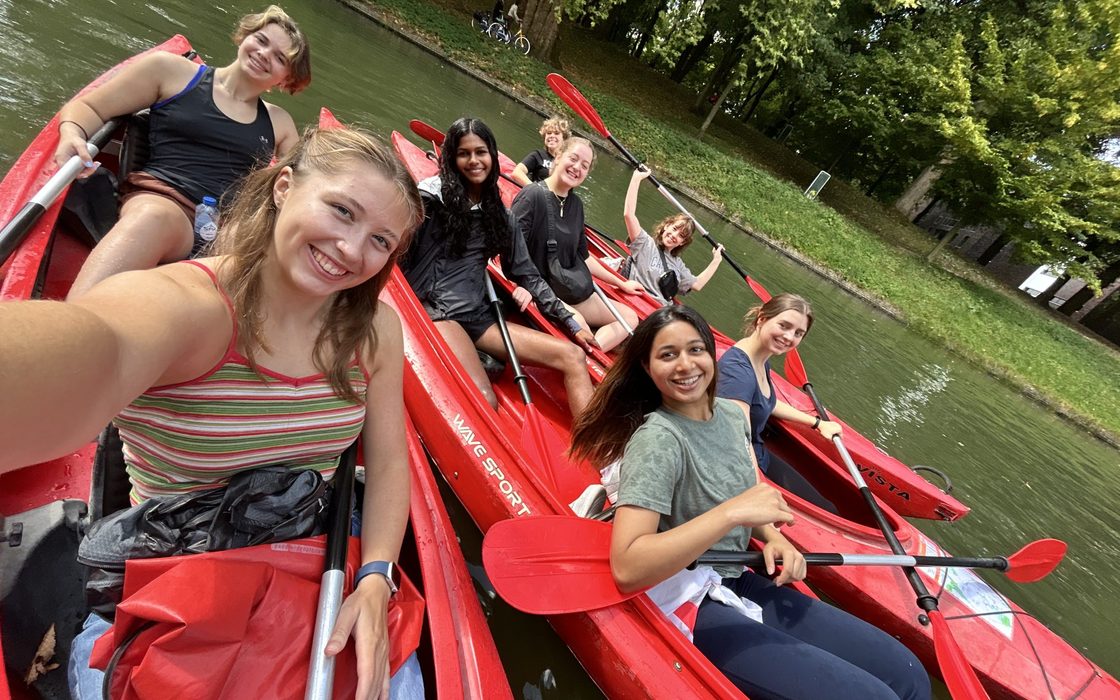 Selfie of students in kayaks on a canel in Amsterdam