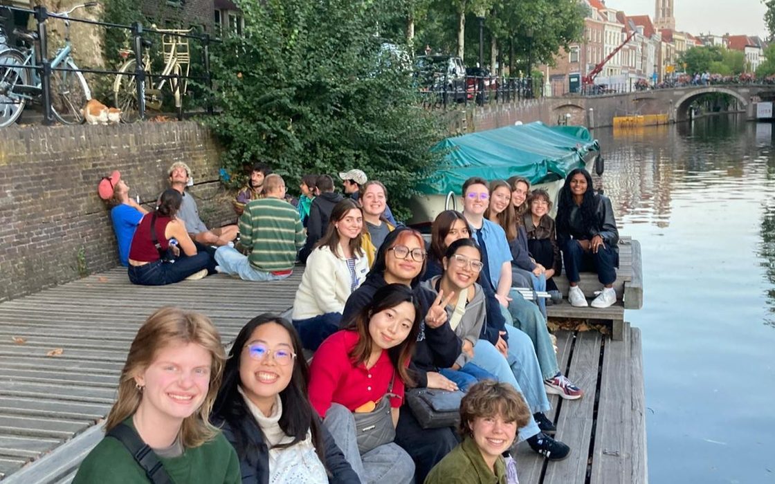 Students relaxing by a canal in Amsterdam