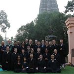 Participants pose in front of temple in meditation clothing