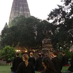Students meditate outdoors in front of the temple