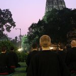 Meditators sit outside of the temple
