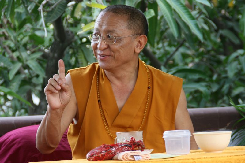 A monk lifts his finger in the air as if to make a point