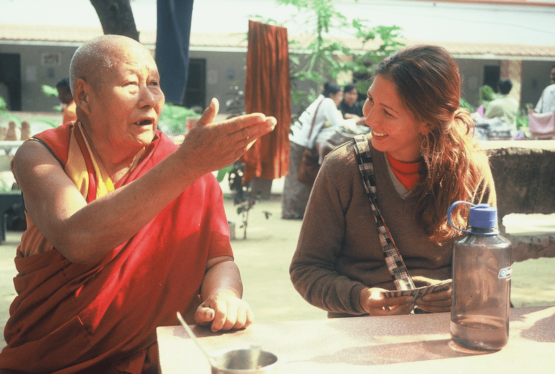 A student smiles as a Geshe talks expressively