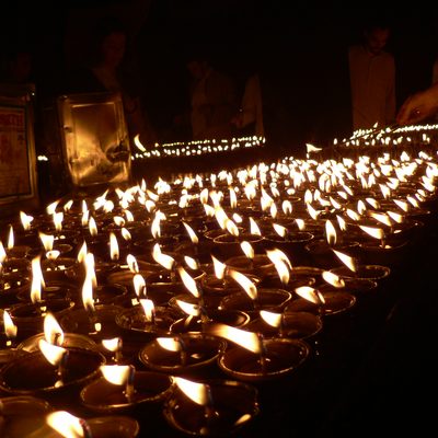 Neat rows of oil lamps contrast with the dark room