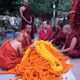 A student chats with a group of smiling monks in red attire