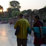 Students carry their meditation mats as the sun sets
