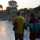 Students carry their meditation mats as the sun sets