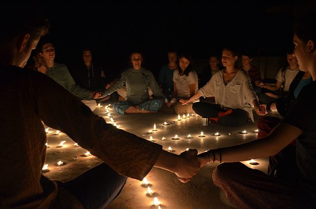 Students holdings hands in candlelit ceremony