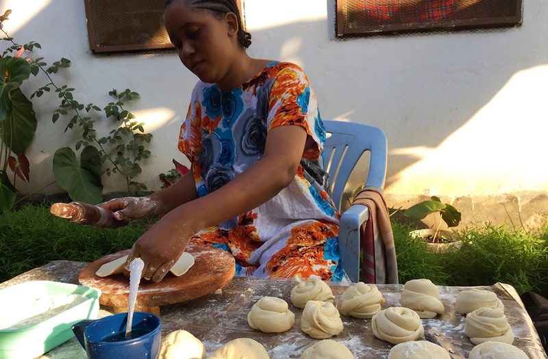 A member of a host family preparing local food