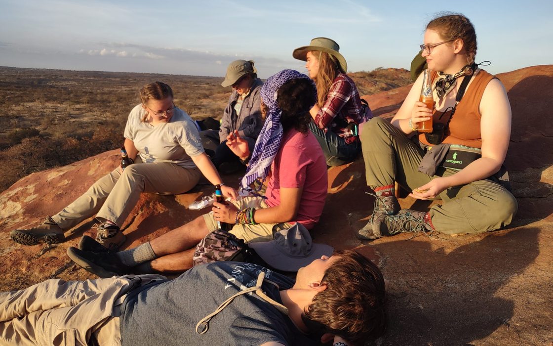 Students enjoy the sunset while on safari