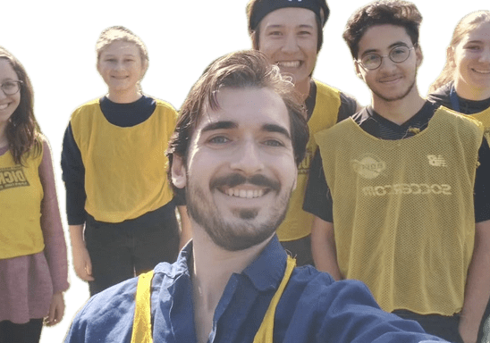 Simon Bouriat-Hardouin takes a selfie with French students wearing yellow practice jerseys