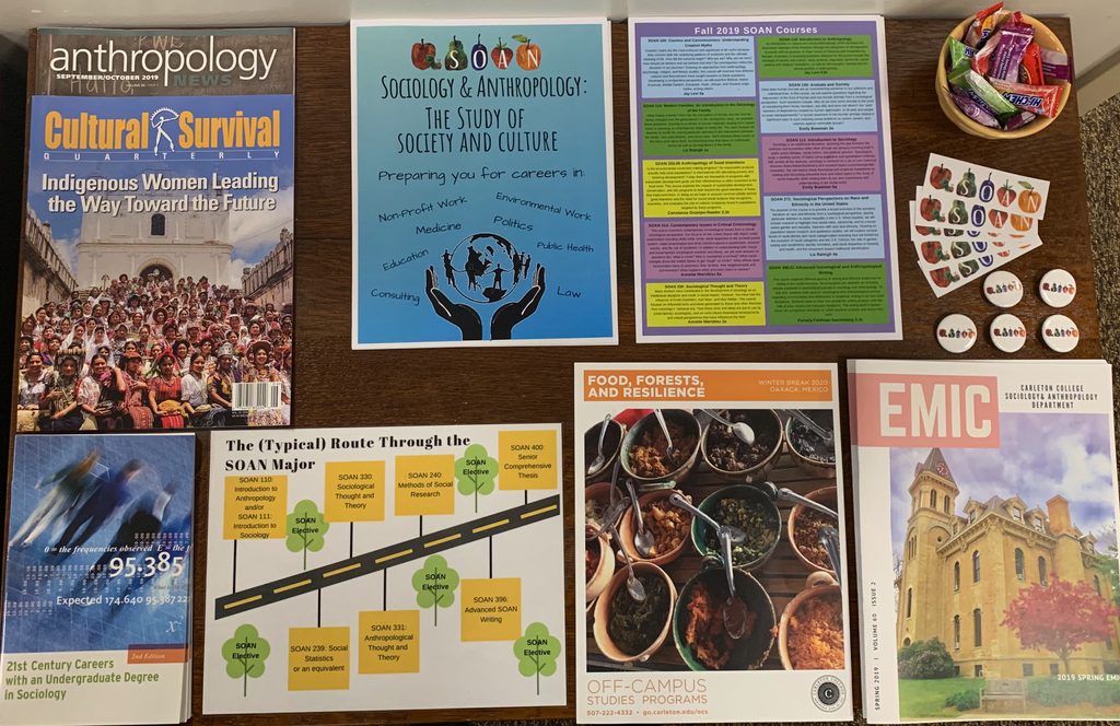 Infographics and posters displayed on a table in the SOAN lounge.
