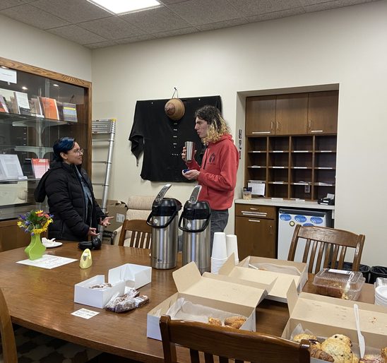Two SOAN students conversing and enjoying coffee in the SOAN lounge at the winter '23 End-Of-Term Party.