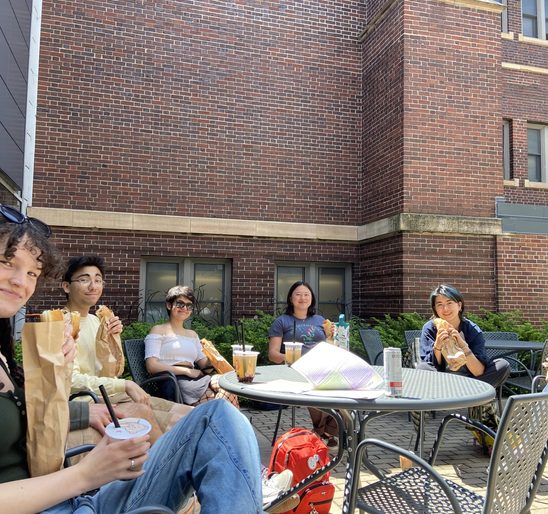 A group of SOAN students enjoying banh mi and bubble tea on the Weitz patio at the spring '24 New Majors Gathering.