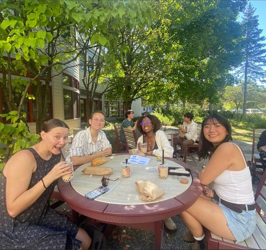 A group of SOAN students enjoying banh mi and bubble tea on the AGH patio at the fall '24 Welcome Back Lunch.