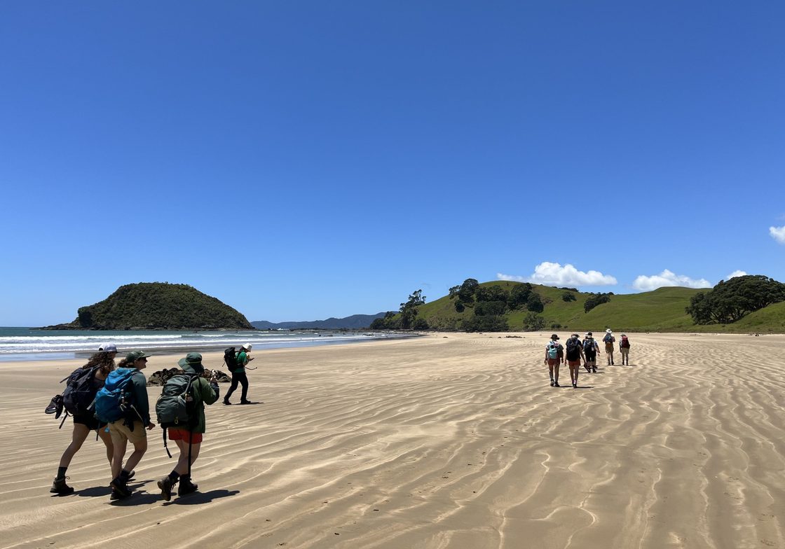Students walking on the Beach with blue skies