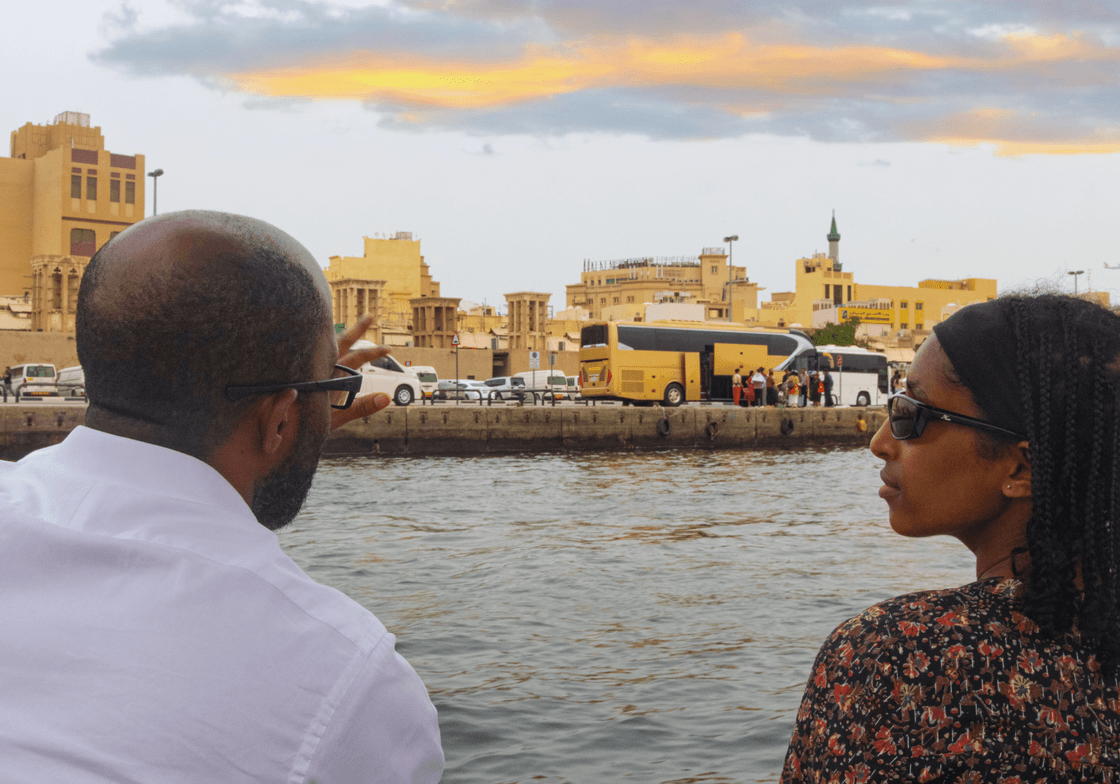Two people overlooking a river and city skyline