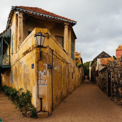 Dirt Road and Houses by Old Rock Wall, Senegal