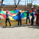 Students Playing Parachute with Service Project Children