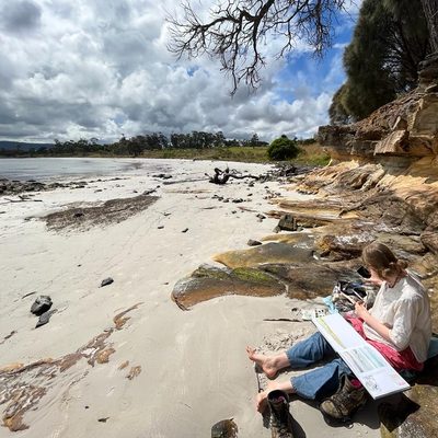 student drawing on the beach in Tasmania