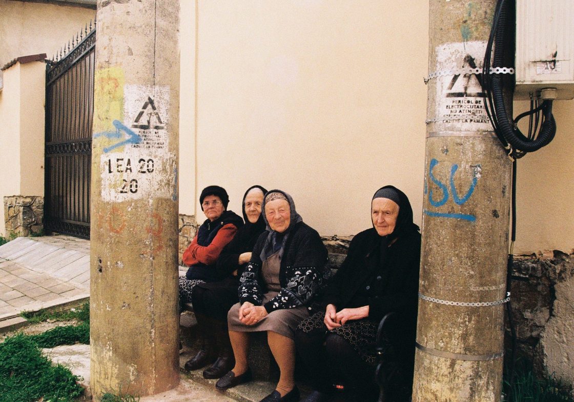 Three old women sit on a bench