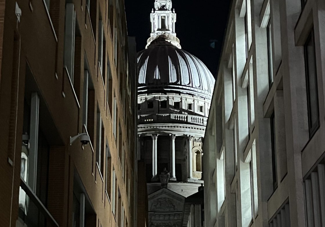 St. Paul's Cathedral viewed through an alley full of small shops.