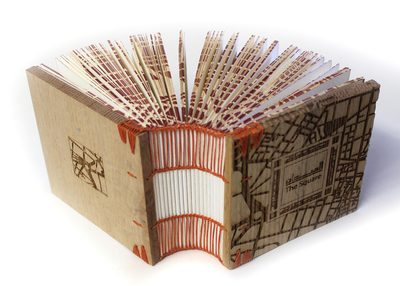 A photo of an artist's book with hand sewn binding and laser cut covers and edges