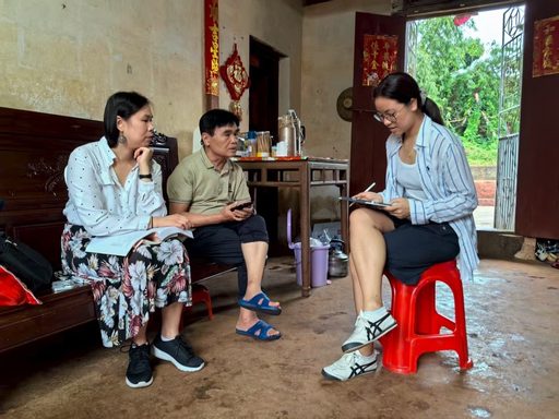 Young woman sitting on a red stool interviewing a couple