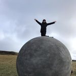 Student on Ball in Iceland, Tali Emlen '22 on the Orbis et Globus in Grímsey. The landmark marks the Arctic Circle.