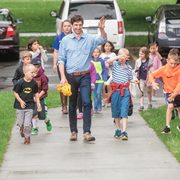 Professor Dan Groll walks on a sidewalk with a group of small children