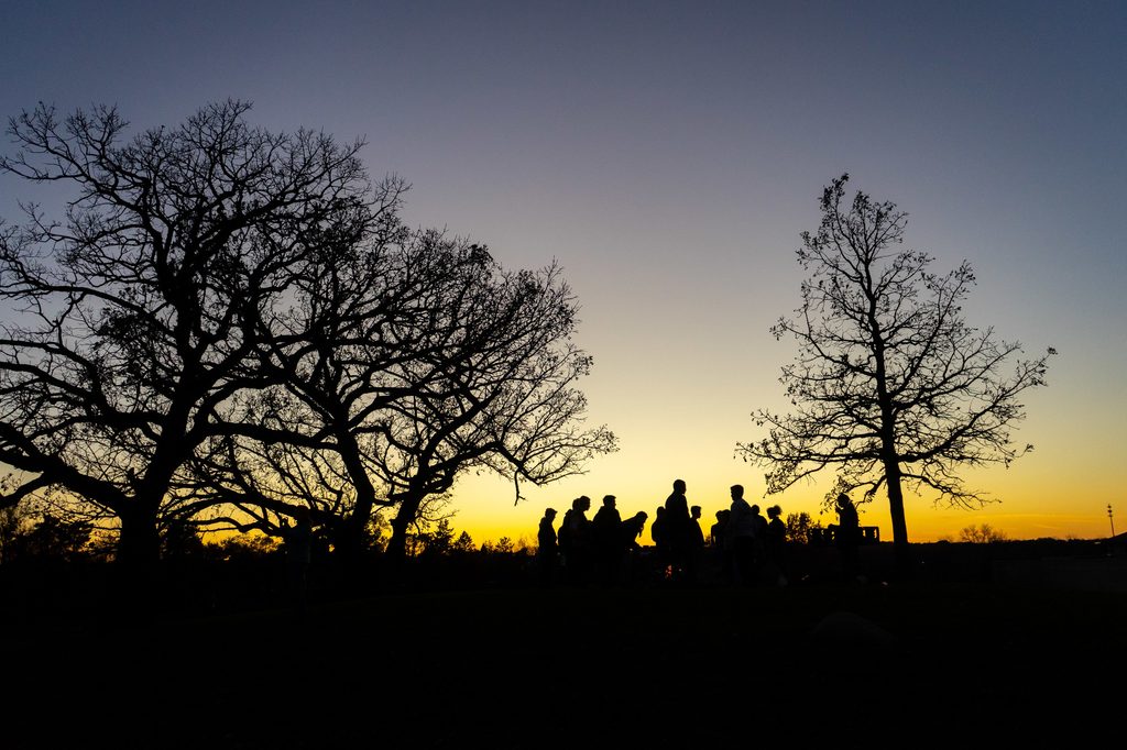 Hill of Three Oaks with silhouetted people