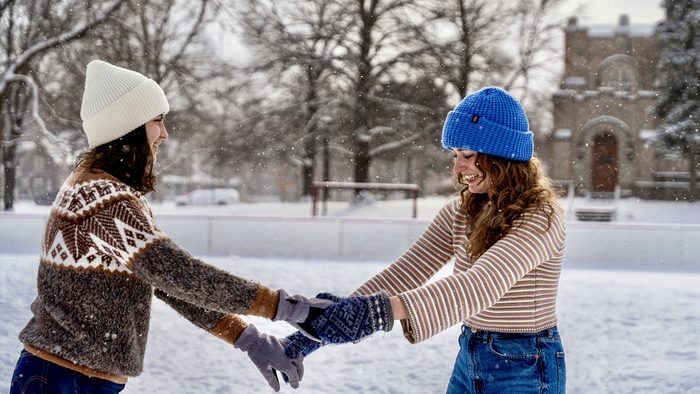 Two students on the Bald Spot ice rink on a snowy day