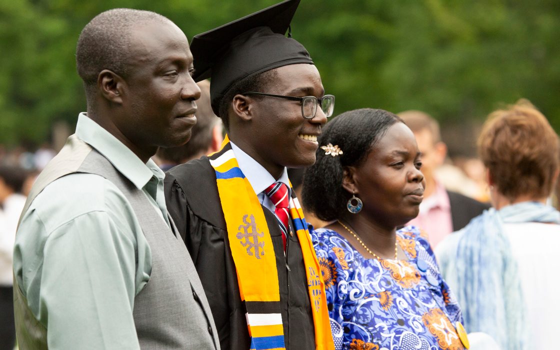 A graduate and his parents at commencement