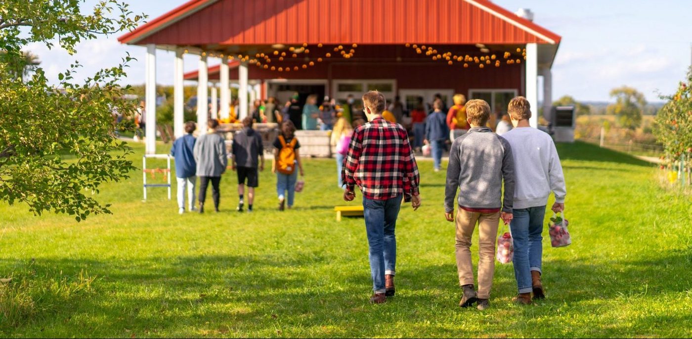 students walk toward a barn at the apple orchard