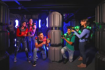 Group of individual playing laser tag next to inflatable objects