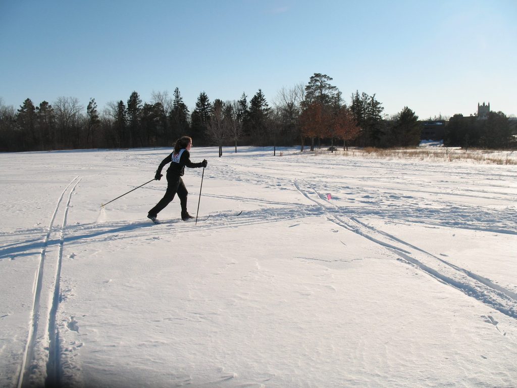 A woman skiing on a snowy field.