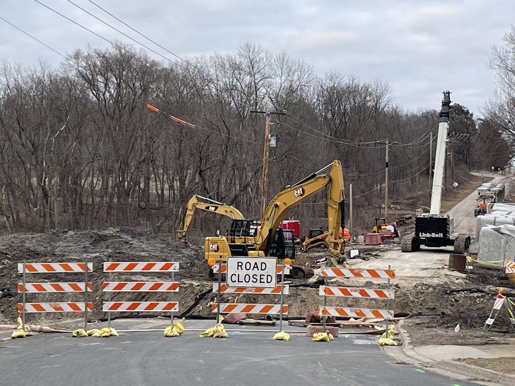 Excavators and road blockers signal road construction on Wall Stree Road