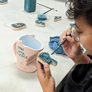 Valentina Guerrero Chala '24 painting a coffee mug for Mini Sota Makoce