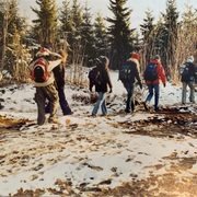 a group of students hiking in a pine forest in winter